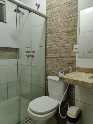 een badkamer met toilet en glazen douche bij Hotel Amazonia in Castanhal