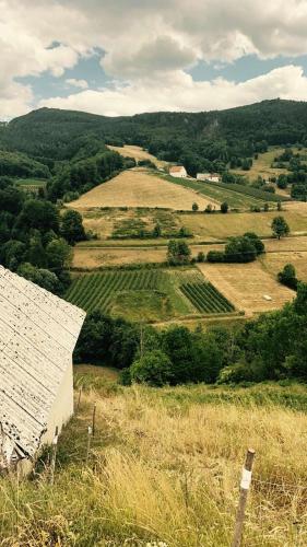 an old barn on a hill with a view of a field at Dedina kuća pod Mučnjem in Ivanjica