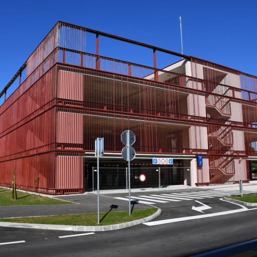 a red building with a parking lot in front of it at Casa Istriana Center with free parking in Koper