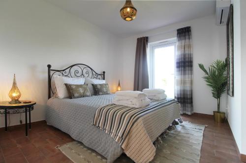 a bedroom with a bed with towels on it at Quinta do Canal in Vila Nova de Milfontes