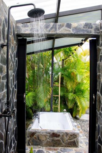 a bathroom with a shower and a bath tub at Orange Eco Villas in Quimbaya
