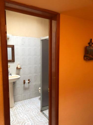 an orange bathroom with a sink and a toilet at Villa Familiar para descanso y convivios fin de semana in Nepantla de Sor Juana Inés de la Cruz