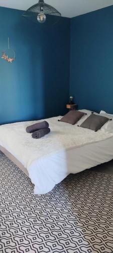 a large bed in a bedroom with a blue wall at MOINES - Centre historique de charme in Vannes