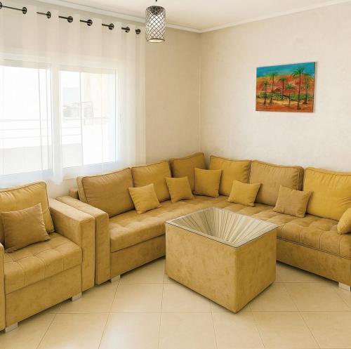 a living room with a couch and a coffee table at Grand Appartement Idéal - Plein Coeur de Kénitra in Kenitra