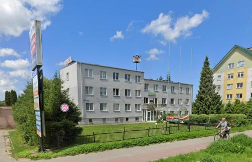a person riding a bike in front of a building at Apart Iwona 209-210 in Koszalin