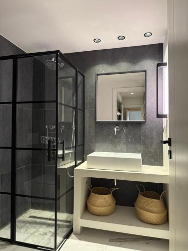 a bathroom with a shower and a sink and a mirror at 2 Bedroom 2 Bath Modern Apartment in Athens