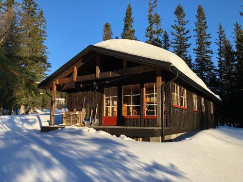 a small building with a snow covered roof in the snow at Bydalsfjällen Östersund Åre Jämtland in Oviken