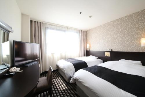 Habitación de hotel con 2 camas y TV de pantalla plana. en APA Hotel Tokyo Kiba, en Tokio