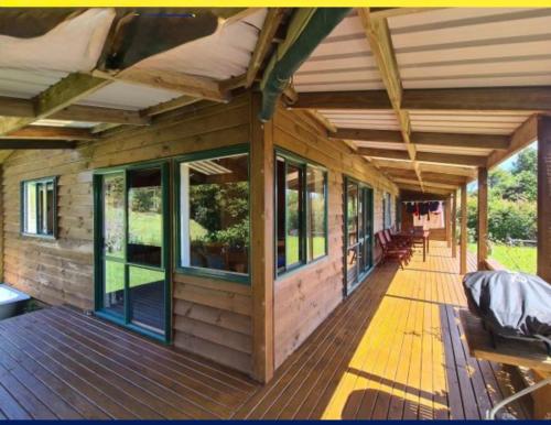 a wooden porch of a house with windows at White Star Station Farm Holiday Park in Coromandel Town