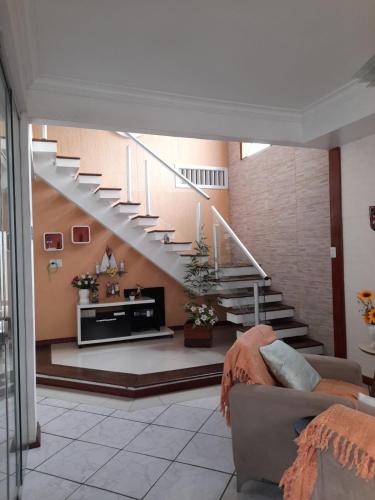 un soggiorno con una scala e un divano di Quartos residencial a Belém