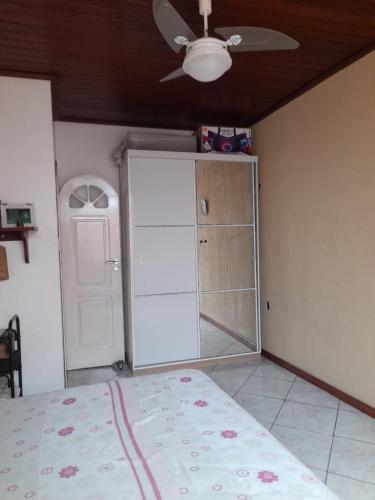 una camera da letto con un letto e un ventilatore a soffitto di Quartos residencial a Belém