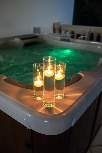 three glasses of water with candles in a swimming pool at Villa Caribe Resort & Spa in Spigno Saturnia