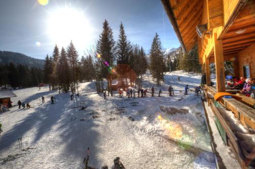 a group of people standing around a fire in the snow at Brunarica in Bohinj