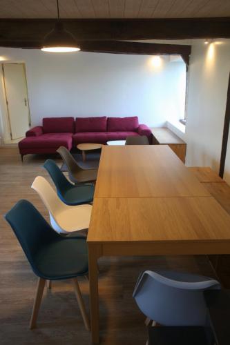 a room with a table and chairs and a couch at Gite Caillebourg Normandie in Saint-Martin-aux-Arbres