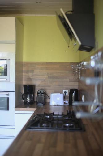 a kitchen with a stove and a counter top at Gite Caillebourg Normandie in Saint-Martin-aux-Arbres