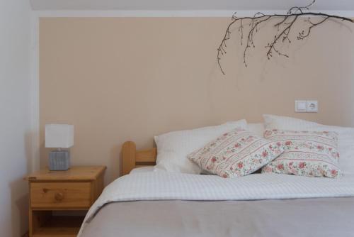 a white bed with two pillows on top of it at Brunarica in Bohinj