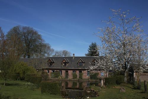 a large brick house in a yard with trees at Gite Caillebourg Normandie in Saint-Martin-aux-Arbres