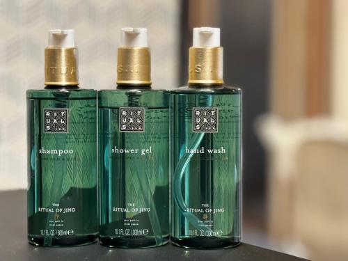 three green bottles sitting on top of a table at Hotel Spa Los Mercaderes in Talavera de la Reina