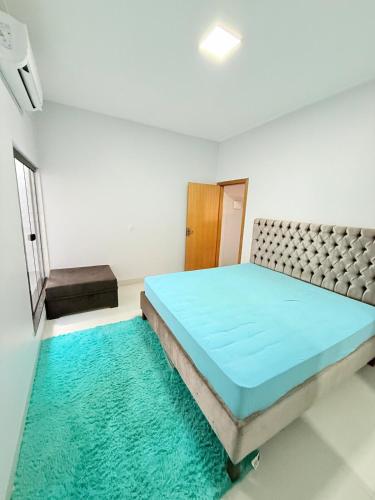 una camera da letto con un letto con un materasso blu e un tappeto di Lar doce Estadia a São Luís de Montes Belos