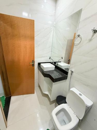 un bagno bianco con un water e un lavandino di Lar doce Estadia a São Luís de Montes Belos