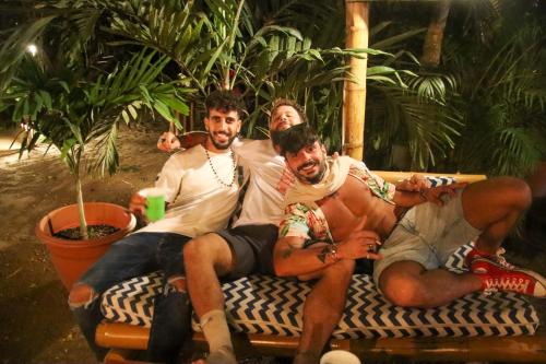 a group of men sitting on a couch at Hidden Hostel in Montañita