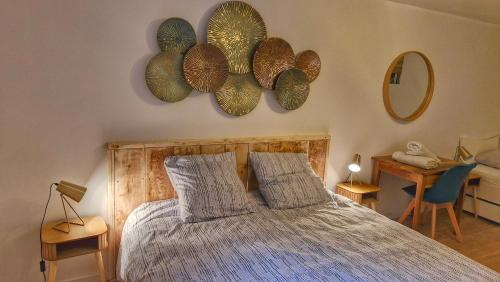 Un dormitorio con una cama y dos espejos en la pared. en Escapade confort, en Bollène
