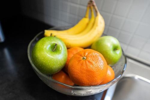 a bowl of fruit with apples oranges and bananas at Outdoor Sauna Hot Tub Playroom Port Dallhousie in St. Catharines
