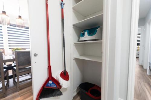 a room with two mop and a broom on shelves at Outdoor Sauna Hot Tub Playroom Port Dallhousie in St. Catharines