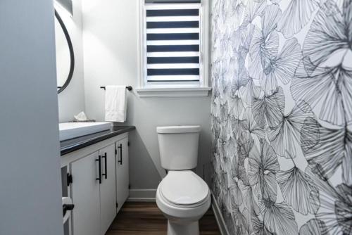 a bathroom with a toilet and a shower curtain at Outdoor Sauna Hot Tub Playroom Port Dallhousie in St. Catharines
