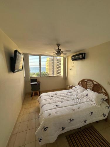 ein Schlafzimmer mit einem Bett und einem Fenster in der Unterkunft Apartamento de Ensueño en Belair Frente al Mar in Caraballeda