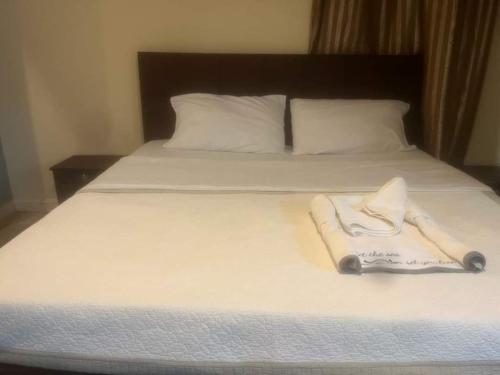 a bed with two white towels sitting on it at Gorilla African Guest House in Entebbe