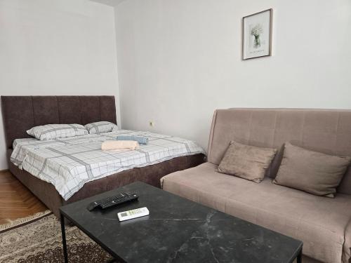 a living room with a bed and a couch at City Haven Prishtina in Pristina