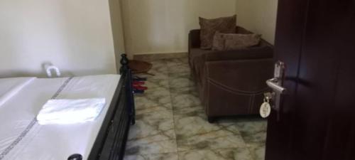 a living room with a bed and a couch at Gorilla African Guest House in Entebbe