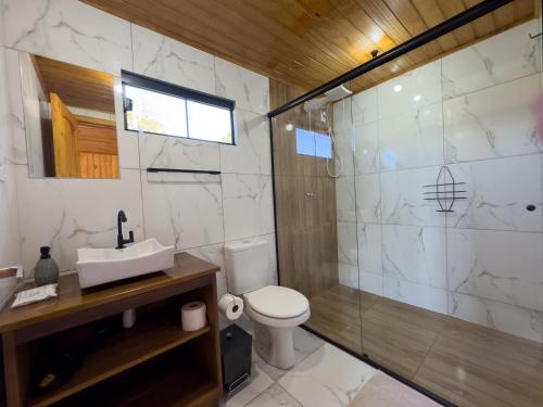 a bathroom with a toilet and a shower and a sink at Morro dos Chalés in Pomerode