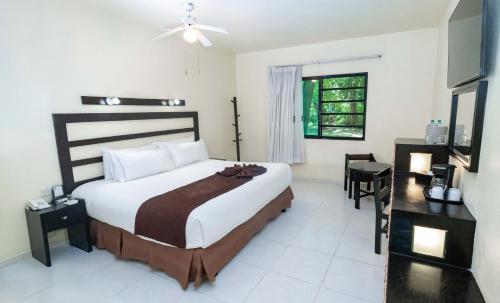 a bedroom with a large bed and a window at Hotel Nututun Palenque in Palenque