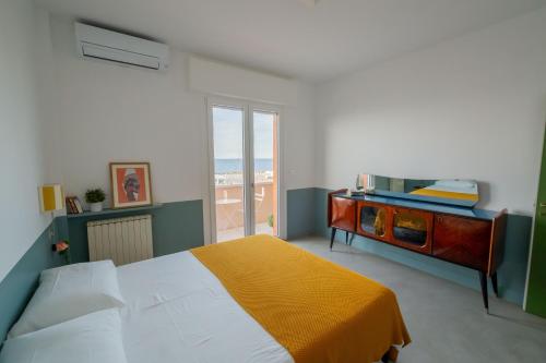 a bedroom with a bed with a dresser and a window at Casa Idillio in Misano Adriatico