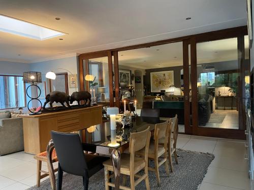 a dining room with a table and some chairs at The Ridgeback, 4 Bedroom Resplendent Living, Bryanston in Johannesburg