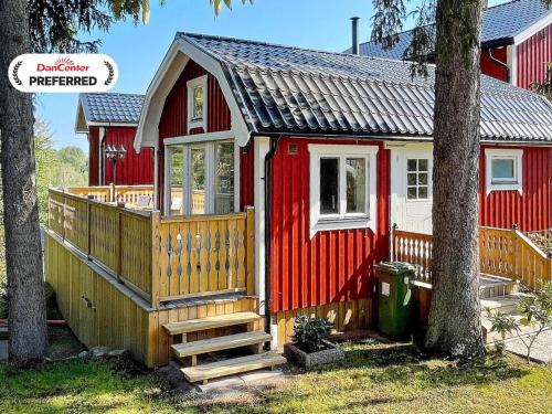 a red and white tiny house with a porch at 4 person holiday home in HUDDINGE-By Traum in Huddinge