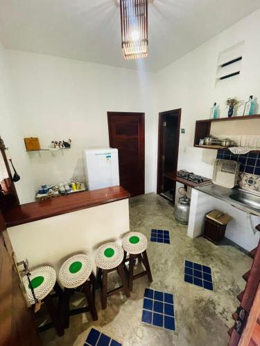 a kitchen with four stools with green plates on them at Bougainville Icaraí de Amontada in Amontada