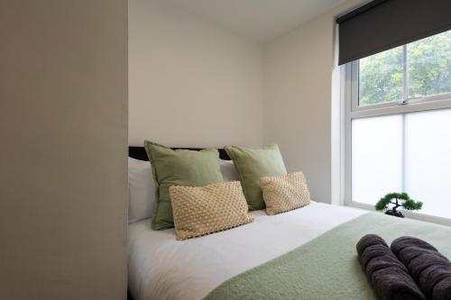 a bedroom with a white bed with pillows and a window at St James Court Hotel in Derby