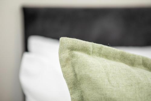 a piece of green cloth sitting on top of a bed at St James Court Hotel in Derby