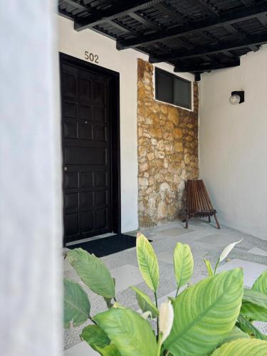 a door of a house with a bench in front of it at Hotel Nututun Palenque in Palenque
