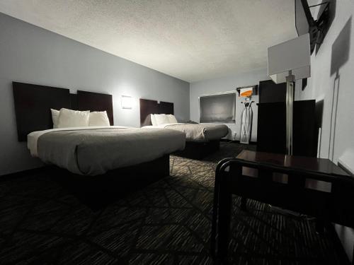a hotel room with two beds and a table at Quality Inn Grand Rapids Near Downtown in Grand Rapids