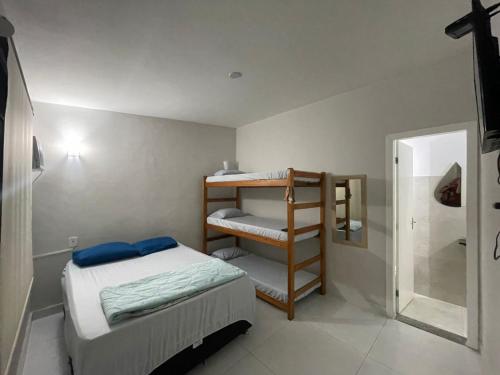 a small bedroom with a bunk bed and a shower at Hostel Caminho do Atlântico in Arraial do Cabo