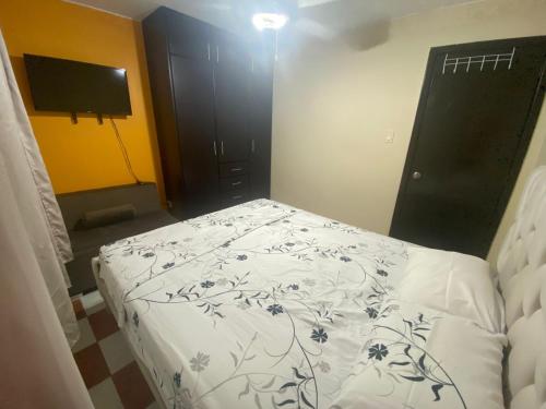 a bedroom with a bed and a black cabinet at Departamento en Tonsupa in Tonsupa