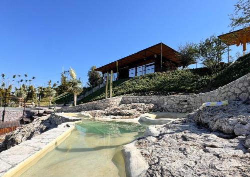 a pool of water in front of a house at Pegaso Retreats San Miguel de Allende in San Miguel de Allende