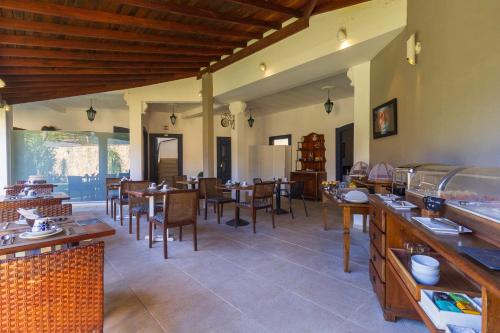 a restaurant with tables and chairs in a room at Pousada Casa dos Autores in Paraty