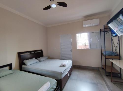 a bedroom with two beds and a ceiling fan at Studio - Ótima localização Mobiliado in Barretos