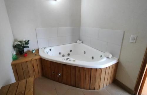 a bath tub in a bathroom with a wooden floor at Departamento 2 ambientes Complejo Amarras Pinamar con pileta y servicios in Pinamar