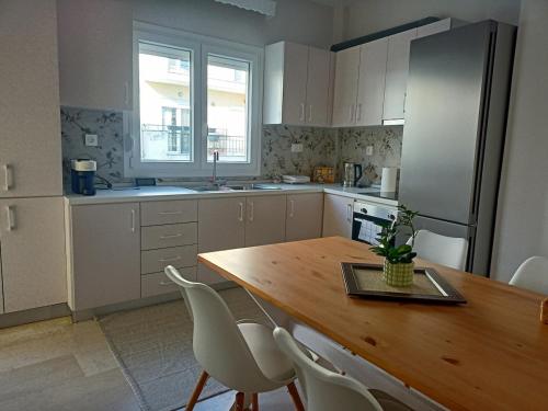 a kitchen with a wooden table and white cabinets at Florina four seasons apartment in Florina